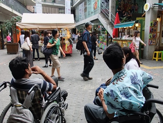 <p>
	The Indian participants (sitting in a wheelchair) in the market are about to do shopping.</p>
