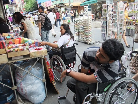 The participants shop in the market (sitting in the wheelchair)