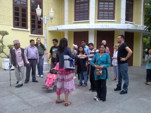 <p>
	A number of participants are standing outside the Exhibition Hall and are looking at Nittayaporn who has her back to the camera.</p>
