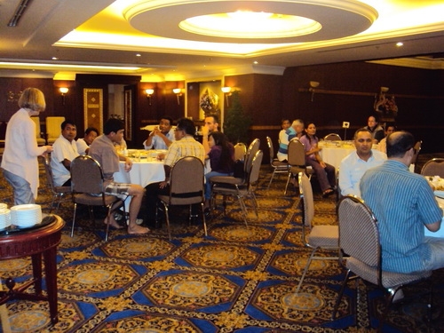 Marcia Rioux stands to the left while speaking to the seated participants. 