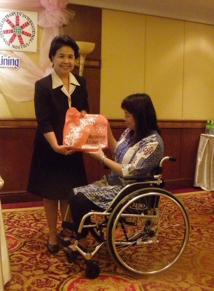 Ms. Kingkaew Inwang smiles while being given a token of gratitude by Ms. Saowalak Thongkuay.