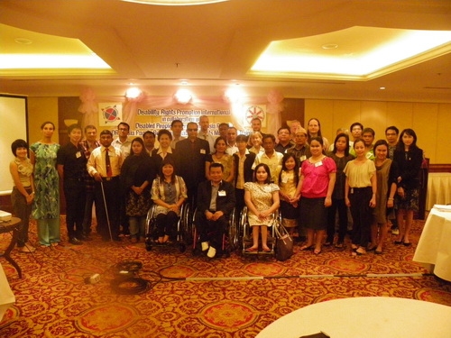 Participants and facilitators pose for a group photo inside the training room. 