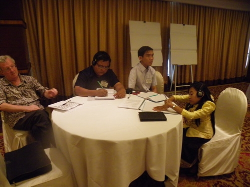 Participants sit around a large round table.