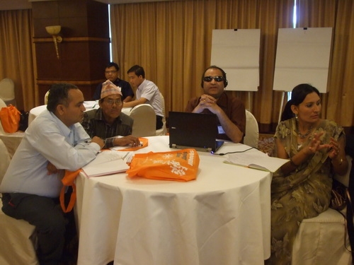 Participants sit around a large round table. 