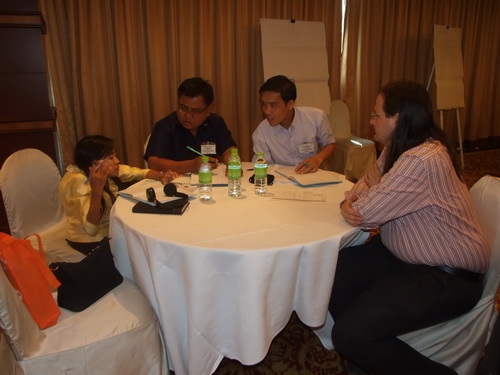 People sitting at a round table talking. 