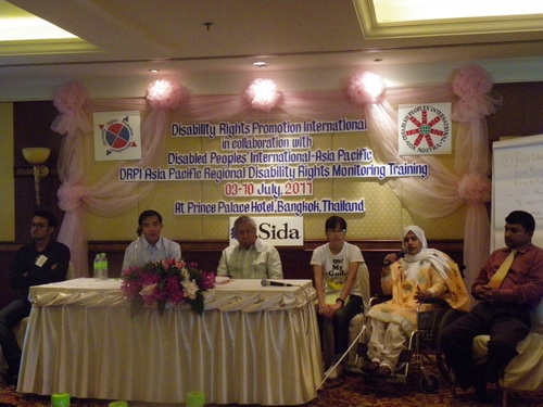 MD Rasel, Ashrafun, Channtey, Lauro, Lapkeo and Roosevelt sit behind a table. Lapkeo speaks into a microphone.