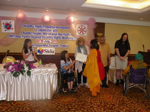 Farhana Mustary of Bangladesh receives her certificate from Saowalak and is congratulated by Marcia Rioux. 