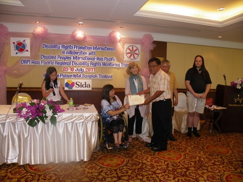 Khamphon Phasayavong smiles holds his certificate with Saowalak Thonkuay while other facilitators look on. 