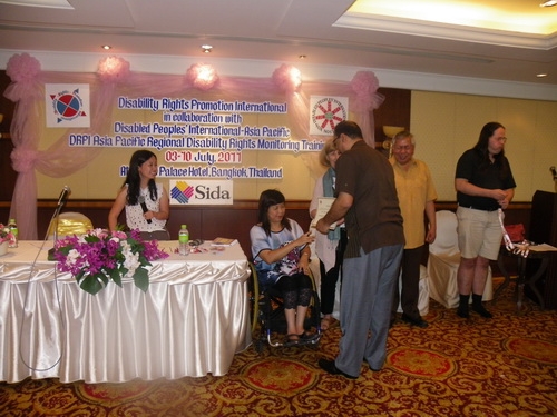 Birendra Raj Pokharel holds his certificate with Saowalak Thonkuay while other facilitators look on. 