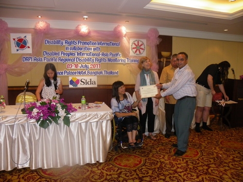 Harka Bahadur Bam holds his certificate with Saowalak Thonkuay while other facilitators look on. 