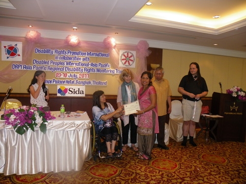 Ram Pyari Karki holds her certificate with Saowalak Thonkuay while other facilitators look on. 