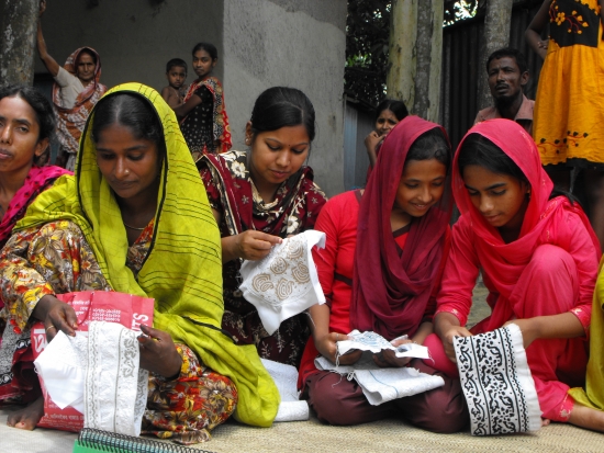 <p>Four women entrepreneurs from a local DPO seated working on sewing crafts</p>
