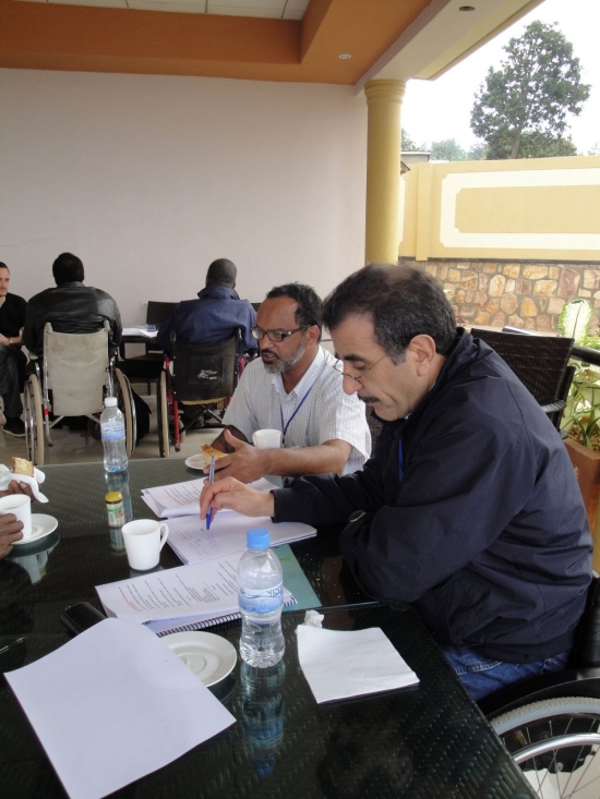 Mohamed El Khadiry and Moosa Salie work at a table covered training materials.