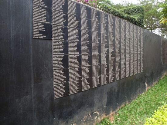 <p>
	A smooth, black stone wall displays many names on plaques</p>
