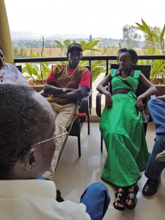 Sam Ntazinda Badege and Mercy Mugure sit on a veranda overlooking the local landscape.
