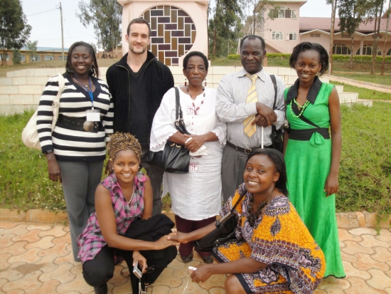 Suzan Kirima, Nkatha Murungi, Mercy Mugure, Felician Mkude, Tiba Kaihuzi, Chris Lytle, and Nancy Amwoso Aswani pose outside in front of the genocide memorial.