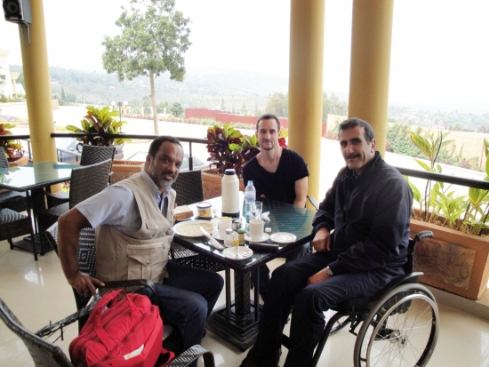 Mohamed El Khadiry (right), Chris Lytle (centre) and Moosa Salie sit at a table on a veranda overlooking the local country side.