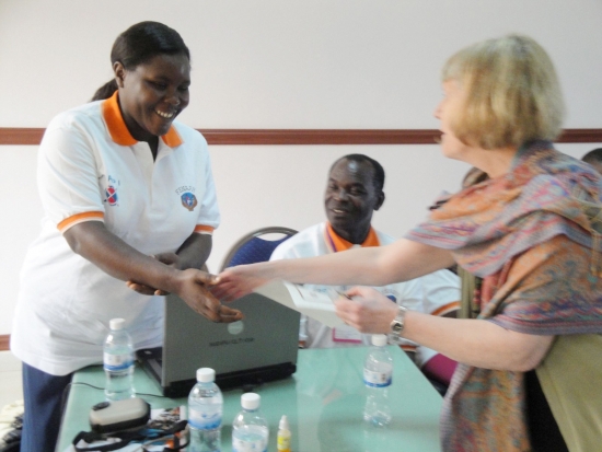 Prof. Marcia shakes hands with Esther Kyozira while giver her a certificate
