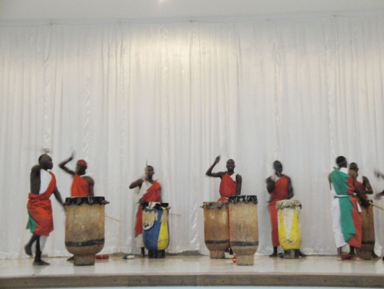 Drummers drum, sing and dance on stage
