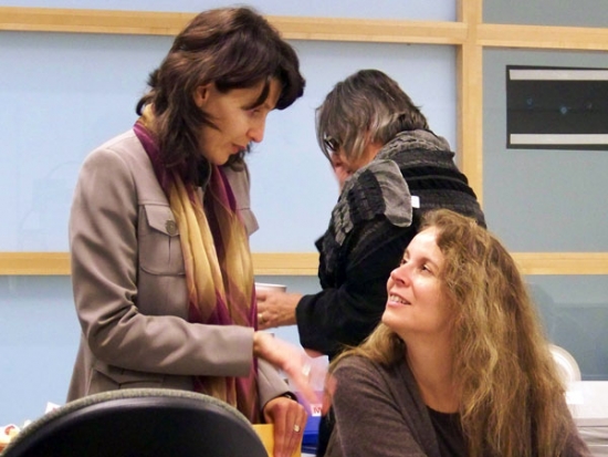 Miha Dinca (standing) is conversing with Dr. Roxanne Mykitiuk (sitting)