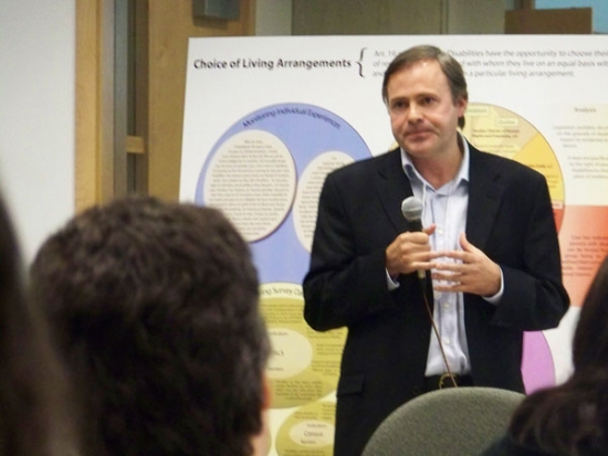 Andrew Laing stands while speaking to the meeting participants