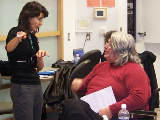 Miha Dinca stands and gestures while speaking with Patrick Fougeyrollas.