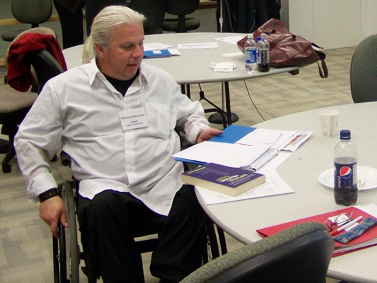 Normand Boucher reads at a round table on his own