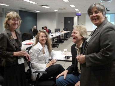 <p>
	Four people are shown at the end of the meeting table, all are laughing while the photo is taken.</p>
