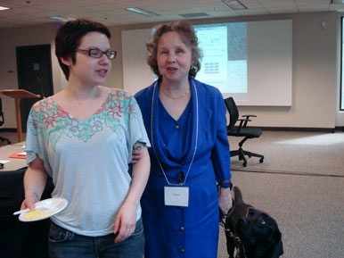 <p>
	Melanie Moore and another participant standing in the meeting room.</p>
