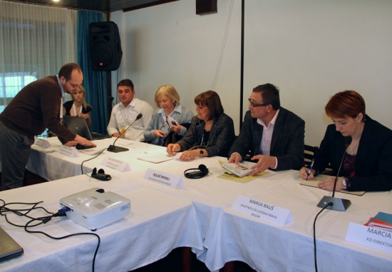 <p>
	Zoltan Mihok is explaining something to the organizational representatives who are all seated behind a long rectangular table with a white tablecloth.</p>
