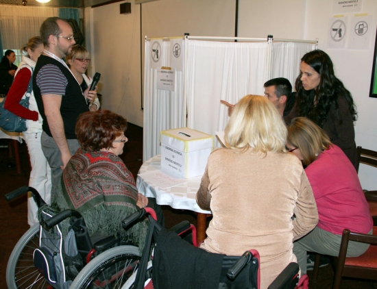 Participants gather around a table with an election box on it.