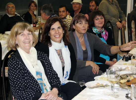 Marcia Rioux, Ljiljana Igrić and Paula Pinto are seated at a long dinner table and smiling.