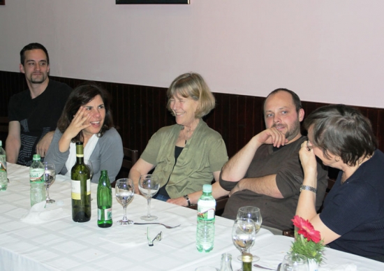 <p>
	Chris Lytle, Paula Pinto, Marcia Rioux, Zoltan Mihok and Ann Marit Saebones sit and laugh next to each other at a long table with wine bottles, water bottles and wine glasses.</p>
