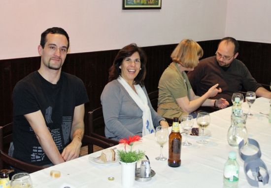 Chris Lytle, Paula Pinto, Marcia Rioux and Zoltan Mihok are seated at a long dinner table. Marica talks with Zoltan while Chris and Paula smile for the picture.