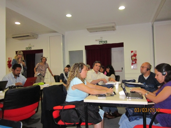 <p>
	Photo of the training room with groups seated at tables working.</p>
