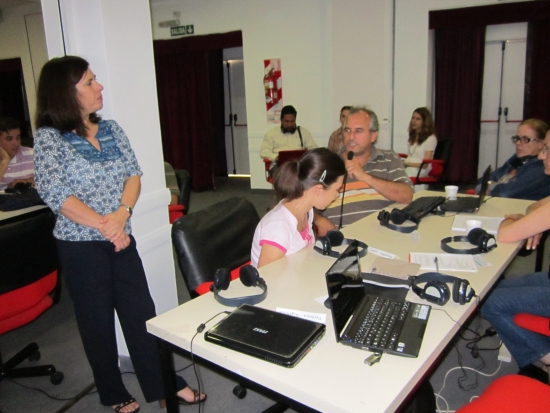 <p>
	Naziberto Oliveira is reporting to the larger group. Sitting at his table are Camila Albin and Andrea Cortes. Paula Pinto is looking at him.</p>
