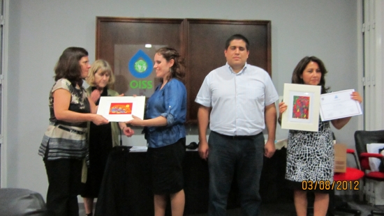 Marcia Rioux, Verónica González, Jose Viera, Ana Lucia Arellano and Paula Pinto during closing ceremony. Paula is handing a frame with an Canadian aboriginal painting to Verónica. Ana Lucia is showing the painting she received and her diploma. 