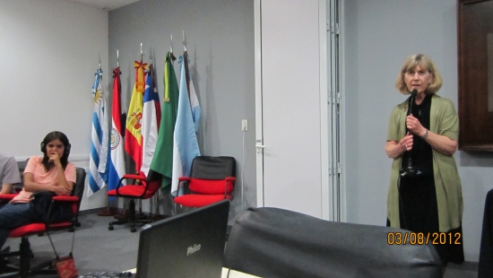 Marcia Rioux speaking during final day of the training. Marcela Omedo is on the left, sitting at her table and listening.