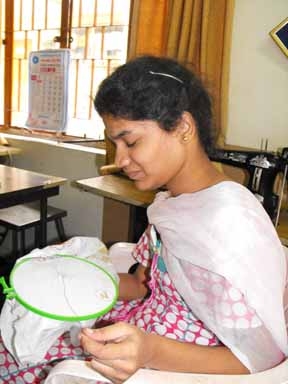 <p>A female trainee at the National Institute for the Mentally Handicapped sits while working on embroidery.</p>
