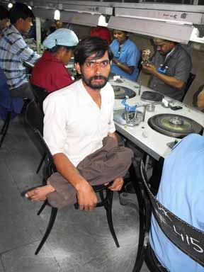 <p>A man poses for the camera from his workstation at Rajiv Gems Park</p>
