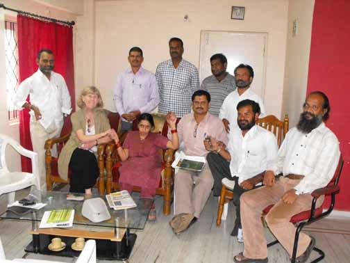 <p>Marcia Rioux poses with several DPO leaders indoors in Hydrobad. Several individuals are holding each others&#39; hands.</p>
