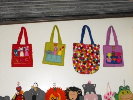 <p>Colourful purses hanging on a wall</p>
