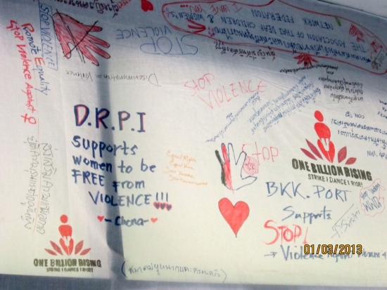 <p>A close up of a white cloth banner covered with writing. One prominent slogan by Chona states &quot;DRPI supports women to be free of violence!&quot;. Most other slogan call to stop violence against women.</p>
