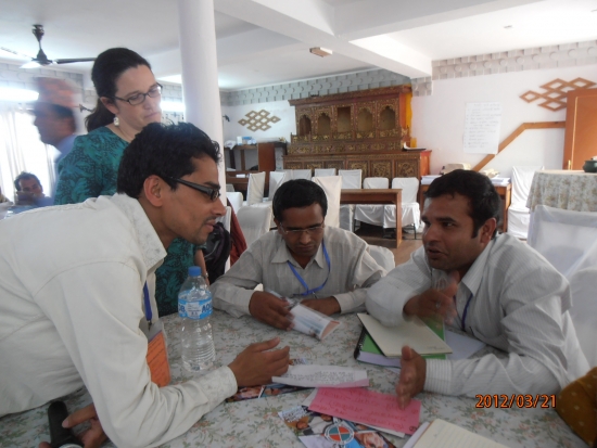 <p>
	Ram and Rita are to the left of two participants that are seated during the training. Ram is leaning over the table to make a point during the discussion.</p>
