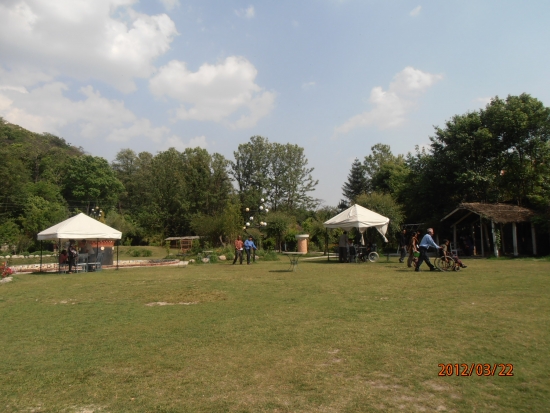 In the back garden there are people assisting guests in wheelchairs.