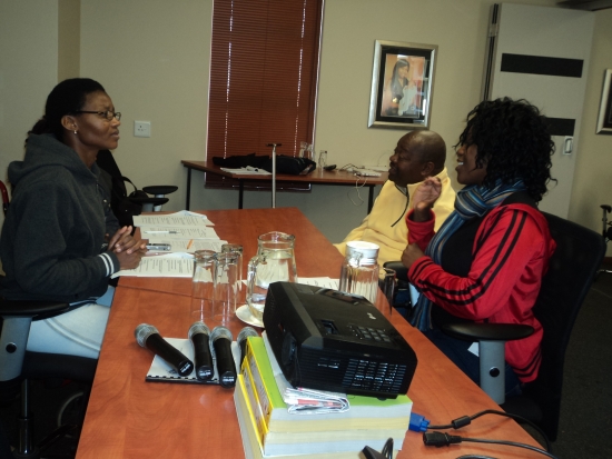Thozama Marasi, Muzi Nkosi and Donecia Mokoena sit at a table in the conference room.
