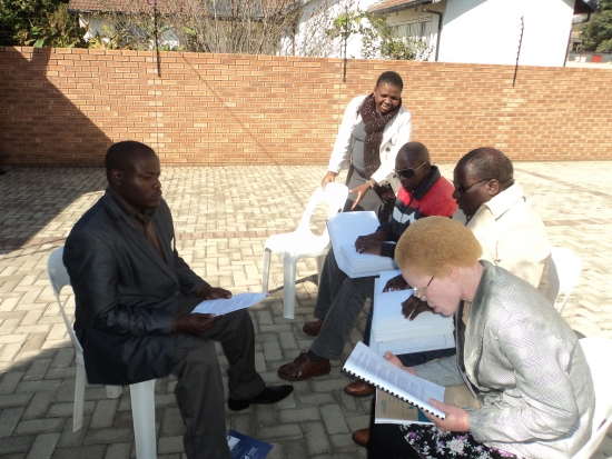 Oswald Tuyizere, Makhi Mfengu, Mnikelwa Nompilwane, Pumla Dyodyo are sitting outside of the training venue. 