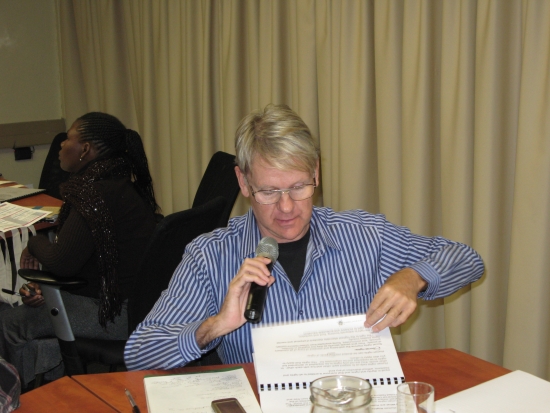 Fanie Swangpogl holds a microphone using his large-printed materials to ask a question in the training venue.