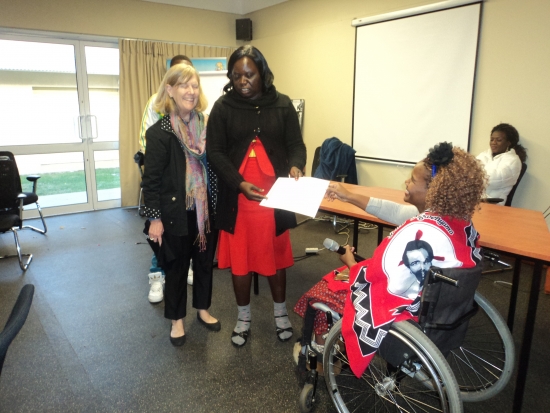 Bongiwe Malope is issuing certificate to Roseweter Mudarikwa, while Marcia Rioux looks on nearby.