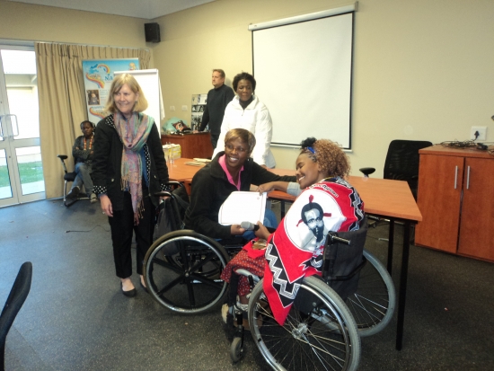 Puleng Moalusi is receiving certificate from Bongiwe Malope who is smiling.